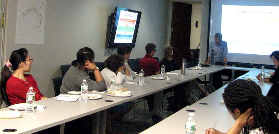 Photo of Bill Imada talking to a seated group.