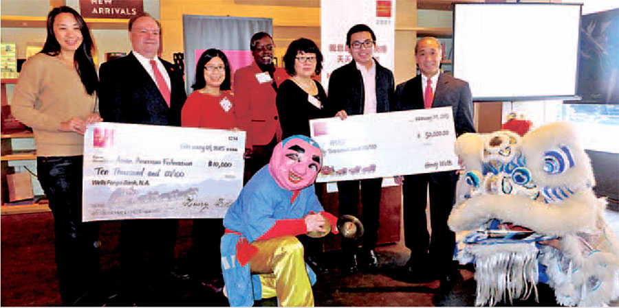 Photo of People holding two large checks alongside Chinese New Year Lion Dancers